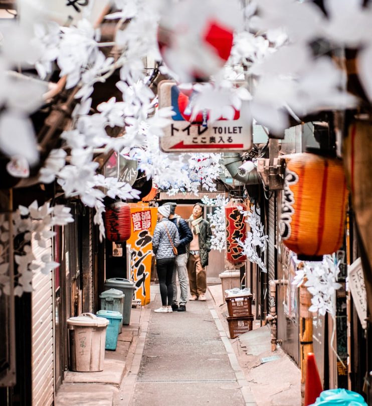 Couple walking through a Tokyo alley with lanterns and cherry blossom